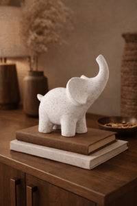Elefante cerámico sobre libros y joyas